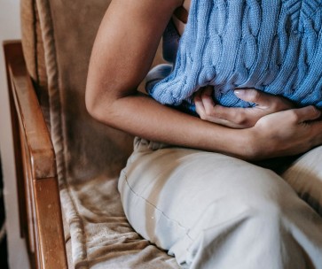 Woman Holding Her Hands against Lower Abdomen