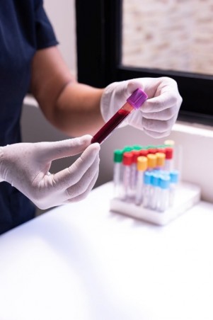 person holding a tube of blood
